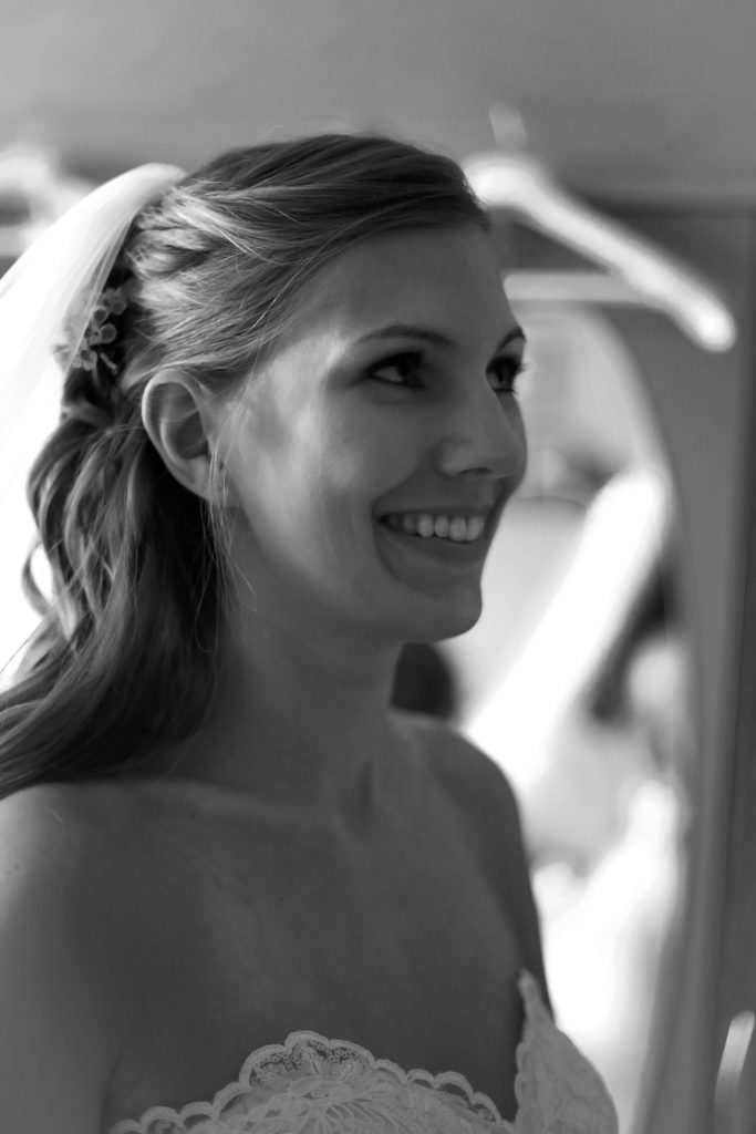 Portraitfoto einer lachenden Braut mit Schleier