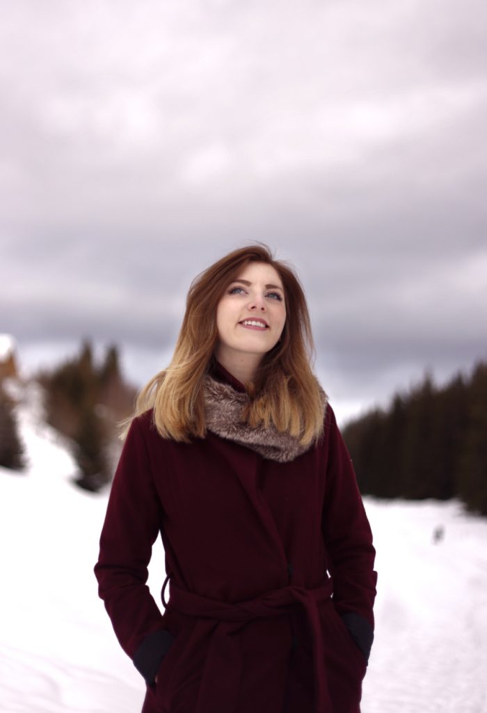 Portraitfoto einer lächelnden Frau im Schnee