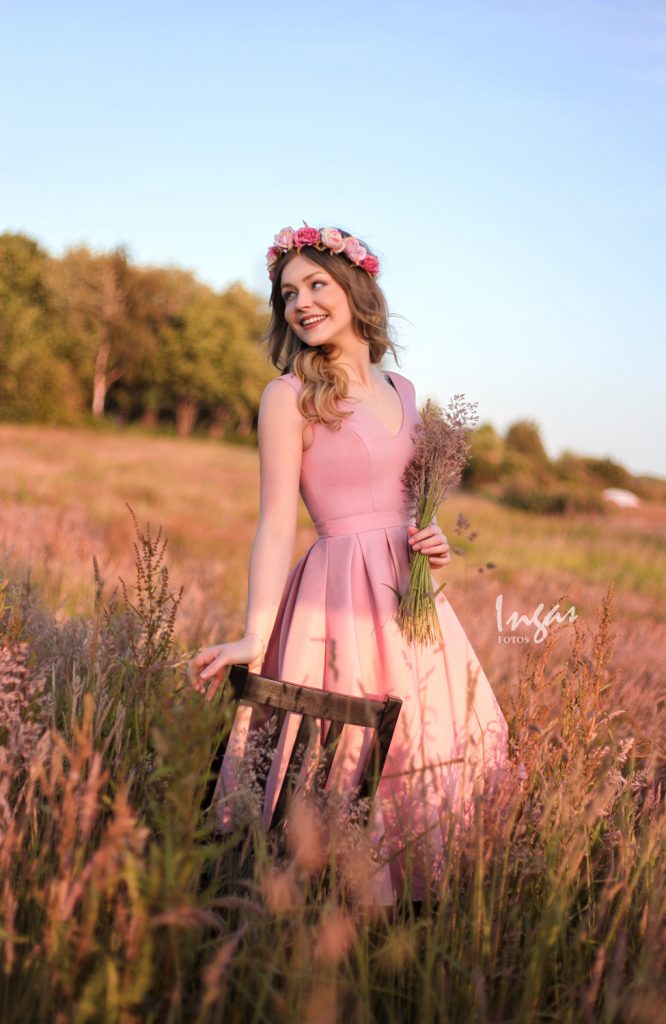 Junge Frau mit Blumenkranz auf einer Blumenwiese