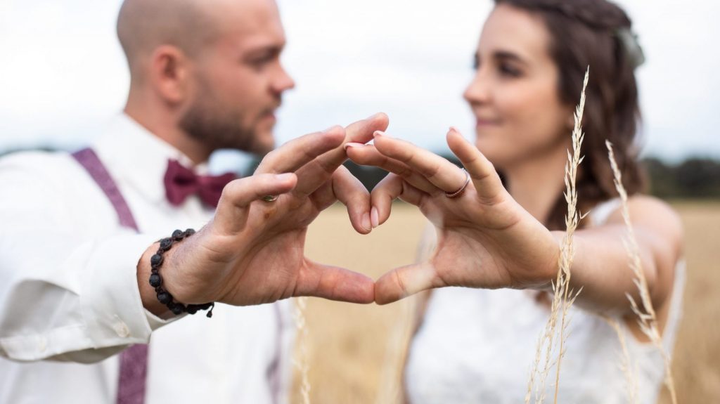 Brautpaar formt mit seinen Händen ein Herz
