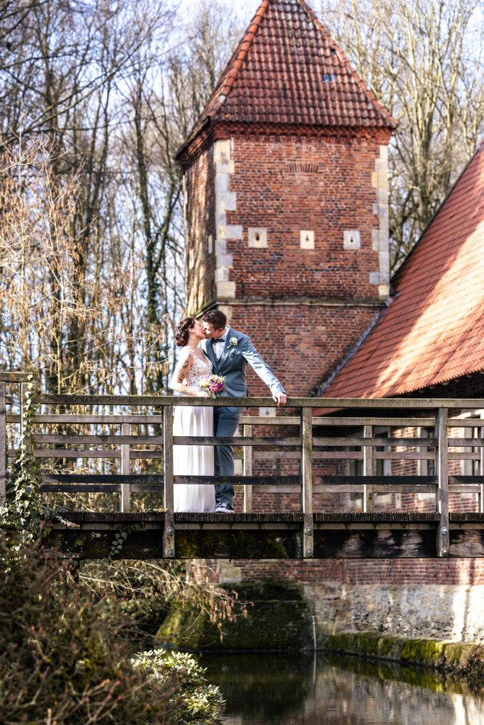 Foto eines Brautpaares auf einer Brücke am Hochzeitstag