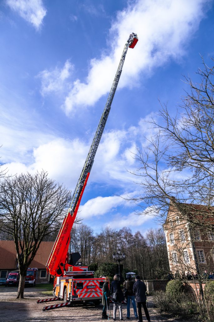 Foto eines Brautpaares am Hochzeitstag in einem Hubsteiger der Feuerwehr