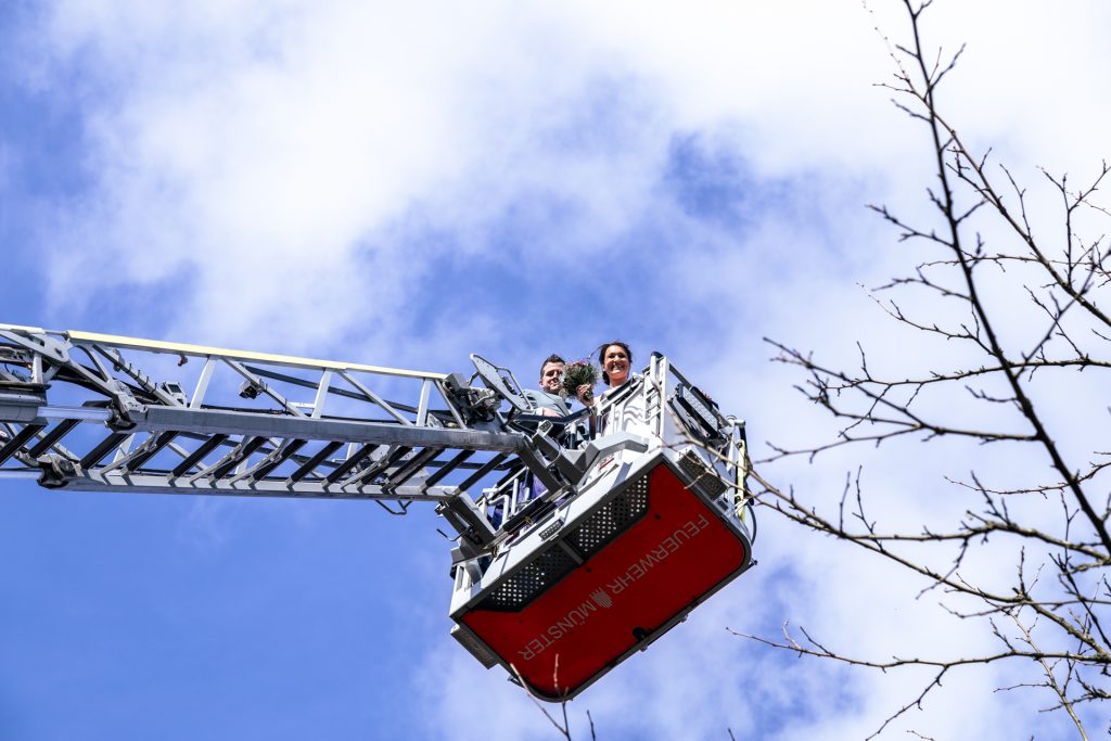 Foto eines Brautpaares am Hochzeitstag in einem Hubsteiger der Feuerwehr