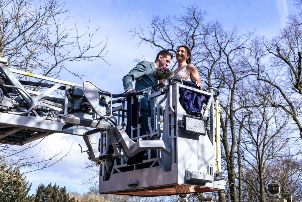 Foto eines Brautpaares am Hochzeitstag in einem Hubsteiger der Feuerwehr