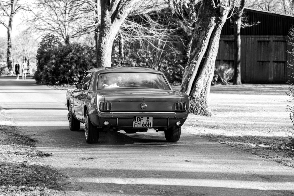 Foto eines Brautpaares am Hochzeitstag in einem Oldtimer