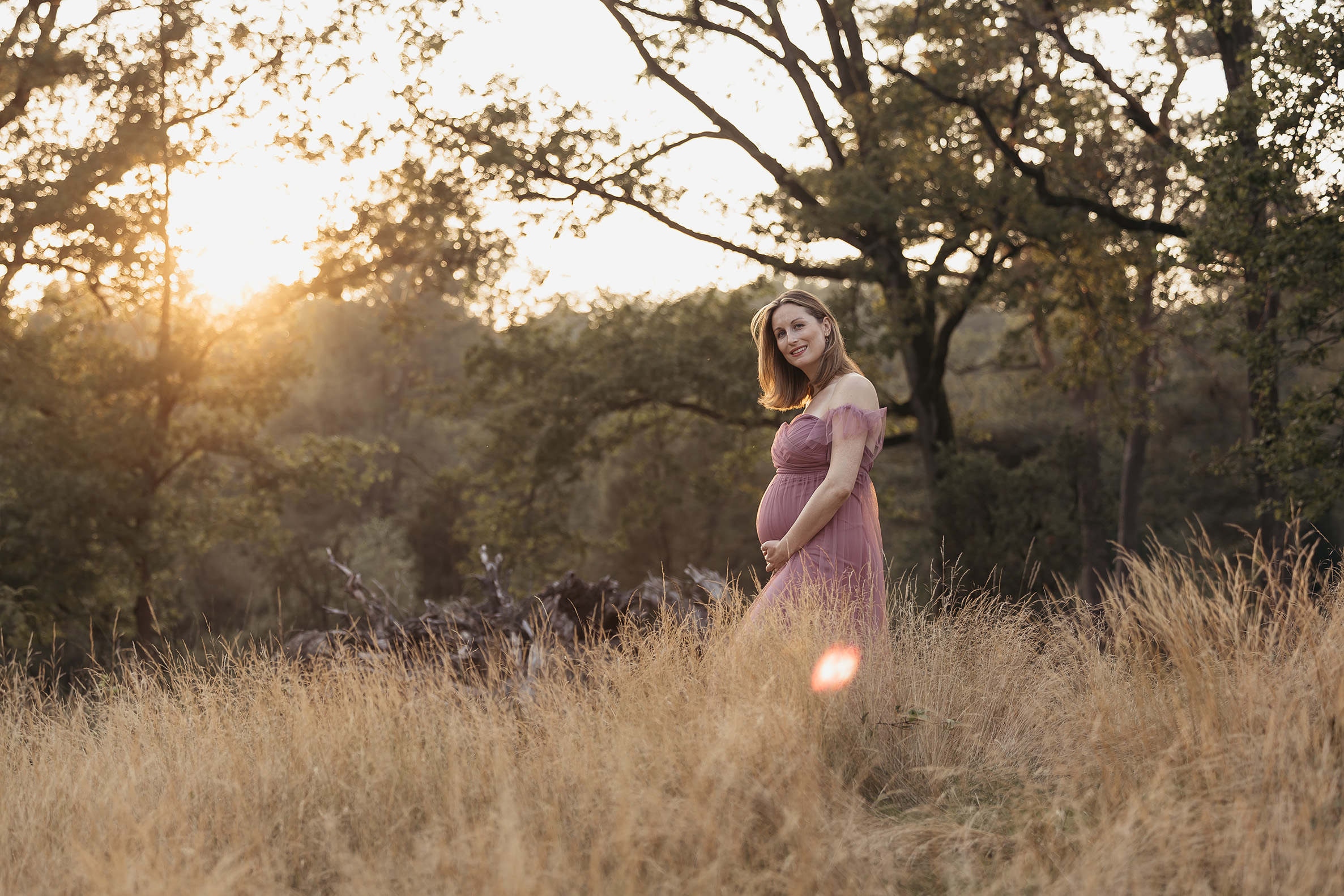 Natürliche Babybauchfotografie draußen in ländlicher Umgebung - Mutter in elegantem langen Kleid